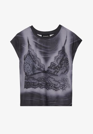 Crna kratka majica s kratkim rukavima s fotografskim printom čipkastog grudnjaka. Ima široki izrez i mekanu teksturu tkanine.
