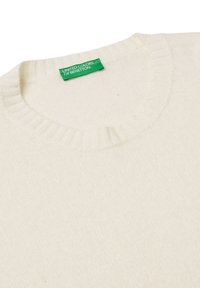 Maglione lavorato a maglia color crema con scollatura rotonda a costine. Presenta un'etichetta verde con la scritta "UNITED COLORS OF BENETTON." Tessuto morbido e strutturato.