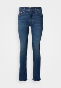 Dunkelblaue Jeans aus Denim mit geradem Bein, ausgestattet mit einem Knopfverschluss, fünf Taschen und dezentem Verblassen an den Oberschenkeln.
