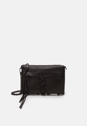Sac bandoulière en cuir noir avec poche avant zippée, fermoir métallique décoratif, pampilles et bandoulière chaîne sur fond blanc.