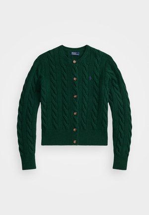 Grønn kabelstrikket cardigan med rund hals, brune knapper, ribbestrikkede mansjetter og falm; har en liten lilla logo på brystet.