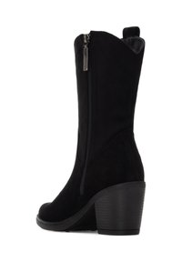 Stivaletto in suede nero con cerniera laterale, tacco affusolato, bordo superiore curvo e suola testurizzata. Presenta un interno liscio.