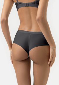 Zwarte hooggewaisted onderbroek, gladde stof, naadloos ontwerp, gematigde bedekking, met een licht gebogen vorm en subtiele textuur.