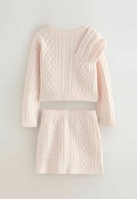 Gaiši rozā adīts džemperis un svārku komplekts ar kabeli rakstu un teksturētām akcentiem. Džemperim ir apaļa kakla izgriezums un ribots piedurknes, svārkiem ir ribots josta.