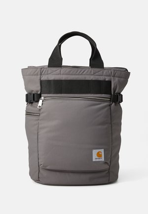 Gray backpack with a quilted design, top handles, adjustable black straps, front zip pocket, and Carhartt logo patch. Features durable fabric.
