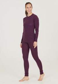 Lila långärmad topp och matchande leggings i ett mjukt, texturerat tyg. Figurpassande design med lång ärmar och ben som når anklarna.