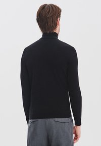 Czarny sweter z golfem wykonany z miękkiego materiału dzianinowego, o dopasowanym kroju i długich rękawach. Gładka faktura i minimalistyczny design.