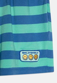 Striped t-shirt in blue and green fabric, featuring an embroidered "Smiley World" tag with three smiley faces at the hem.