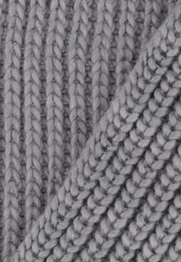 Szara dziana tkanina z uwypukloną teksturą prążków, wykonana z grubej włóczki. Włókna wydają się miękkie i grube, co zwiększa ciepło i komfort.