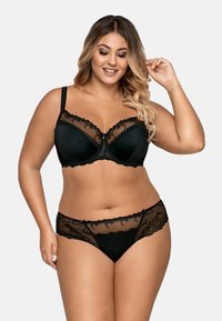 Zwart kanten lingerieset met een onderwired beha met bloemenaccenten, transparante panelen en bijpassende transparante slipjes met kanten rand.