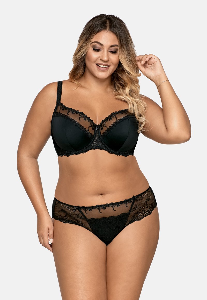 Zwart kanten lingerieset met een onderwired beha met bloemenaccenten, transparante panelen en bijpassende transparante slipjes met kanten rand.