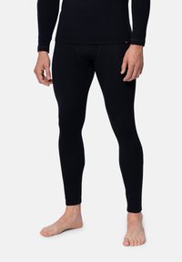 Schwarze thermische Leggings aus dehnbarem Material, mit einer eng anliegenden Passform, glatter Textur und elastischem Bund.