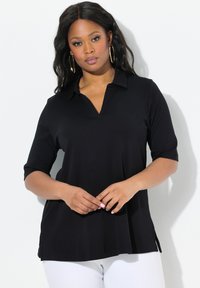 Tutina nera con colletto, maniche 3/4, spacchi laterali e vestibilità comoda. Realizzata in tessuto morbido, presenta una superficie liscia e un design minimale.
