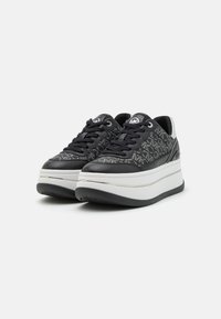 Černé platformové tenisky s koženým a vzorovaným textilním svrškem, bílou mezipodešví, černou podrážkou a černými šňůrkami. Stříbrné akcenty a detail loga.