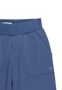 Modré bavlnené tepláky s elastickým pásom, dvoma prednými vreckami a malým Embossed logom na dolnom vrecku.