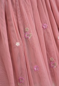 Rosa Tüllkleid mit verstreuter floralem Stickerei in hellem Rosa und Creme, ausgestattet mit einer weichen, durchsichtigen Textur und einem geschichteten Design.