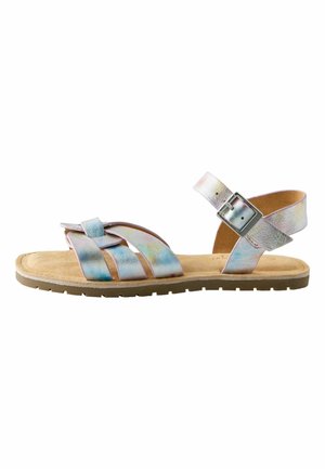 Flat sandal with beige sole and iridescent leather straps, featuring a buckle closure around the ankle.