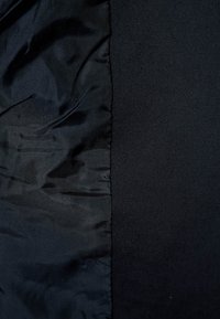 Black fabric divided into two textures: smooth satin on the left and a more textured weave on the right, both in varying shades of black.