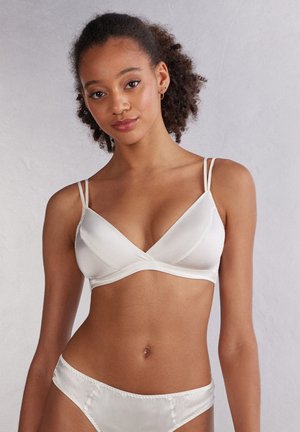 Witte satijnen bralette met dunne verstelbare banden, V-halsontwerp, zachte textuur en bijpassende hoge taille slip.