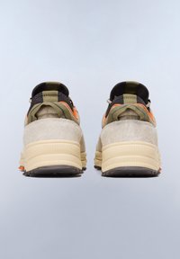 Tenisky s béžovým semišovým svrškem, olivově zelenými akcenty, černým podpatkem a oranžovými detaily. Robustní podešev s texturovaným gumovým vzorem.
