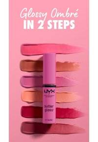 Gloss à lèvres rose conditionné dans un tube cylindrique haut avec une finition brillante. Des échantillons de diverses couleurs de lèvres dans des teintes ombrées sont disposés derrière.