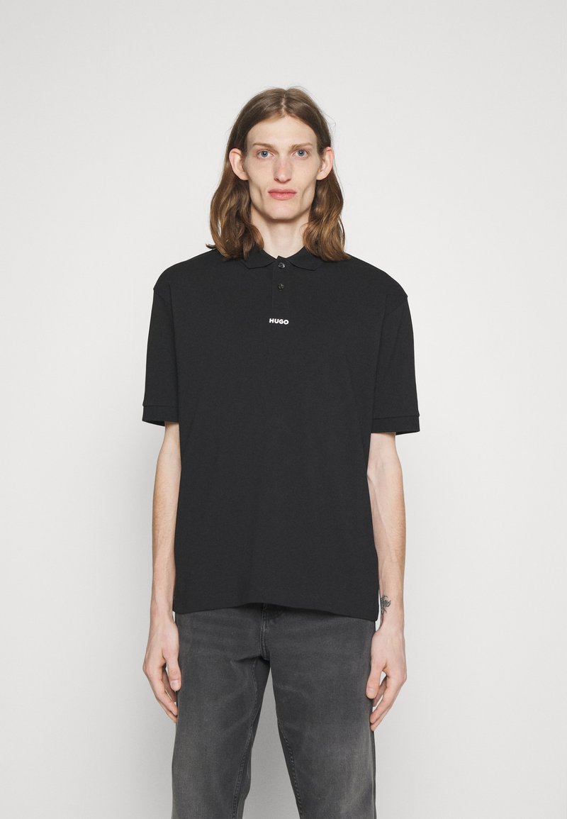 Tricou polo negru cu guler, având o plachetă cu trei butoane și logo-ul alb "HUGO" pe piept. Material din bumbac moale, croială lejeră.