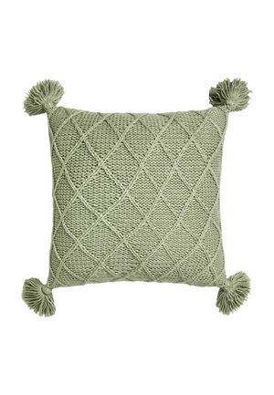 Green knitted square pillow with diamond pattern and tassels on each corner on a white background.