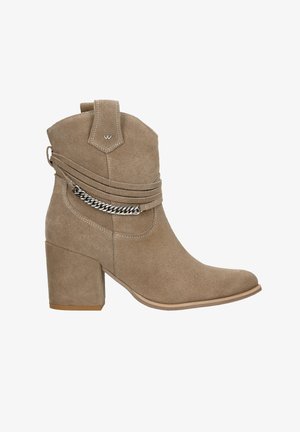 Beige suède enkellaarsjes met een spits toelopende neus, lage blokhak, zijkettingaccent en gestikte details op het bovenwerk.