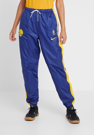 Blaue Sporthosen mit gelben Seitenstreifen, versehen mit einem Basketball-Logo und Nike-Branding. Hergestellt aus leichtem, glattem Material.
