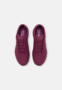 Baskets athlétiques bordeaux avec tige perforée, bout rond et semelle rembourrée. Comprend des lacets assortis et des semelles intérieures signées.