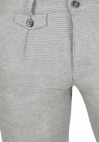 Grijze houndstooth-gepatenteerde broeken van gestructureerde stof, met voorzakken en een knoopsluiting.