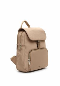 Beež seljakott klapiga, eesmine tõmblukuga tasku, sile nailonmaterjal, reguleeritavad sangad ja metallist tõmblukud. Kompaktne disain minimaalse riistvaraga.