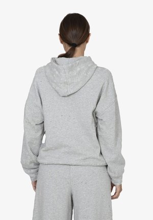 Felpa grigia con cappuccio, vestibilità rilassata e spalle scese. Realizzata in tessuto testurizzato con piccole imperfezioni e polsini elasticizzati.