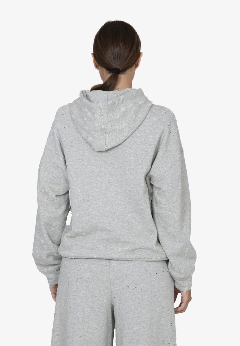 Felpa grigia con cappuccio, vestibilità rilassata e spalle scese. Realizzata in tessuto testurizzato con piccole imperfezioni e polsini elasticizzati.
