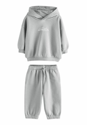 Jasnoszara dziecięca bluza z kapturem z napisem "Athletic" oraz pasujące dresowe spodnie z elastyczną talią i ściągaczami.