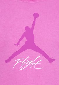 Felpa rosa con una grande silhouette viola di un giocatore di pallacanestro che salta per fare un dunk, con la parola "Flight" in carattere corsivo bianco sottostante.