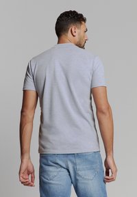 Grijze katoenen t-shirt met korte mouwen, aansluitend ontwerp, ronde hals en een gladde textuur, gecombineerd met lichtblauwe denim jeans.