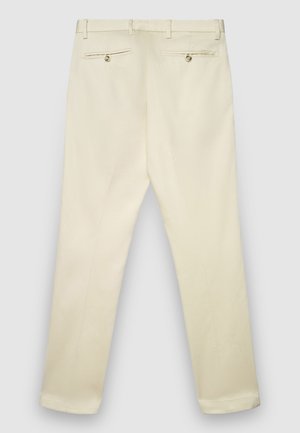 Beige Hose mit geradem Schnitt, versehen mit zwei Gesäßtaschen mit Knöpfen, hergestellt aus glattem Stoff und am Saum an den Knöcheln abgeschrägt.