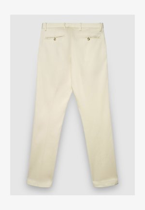 Beige Hose mit geradem Schnitt, versehen mit zwei Gesäßtaschen mit Knöpfen, hergestellt aus glattem Stoff und am Saum an den Knöcheln abgeschrägt.