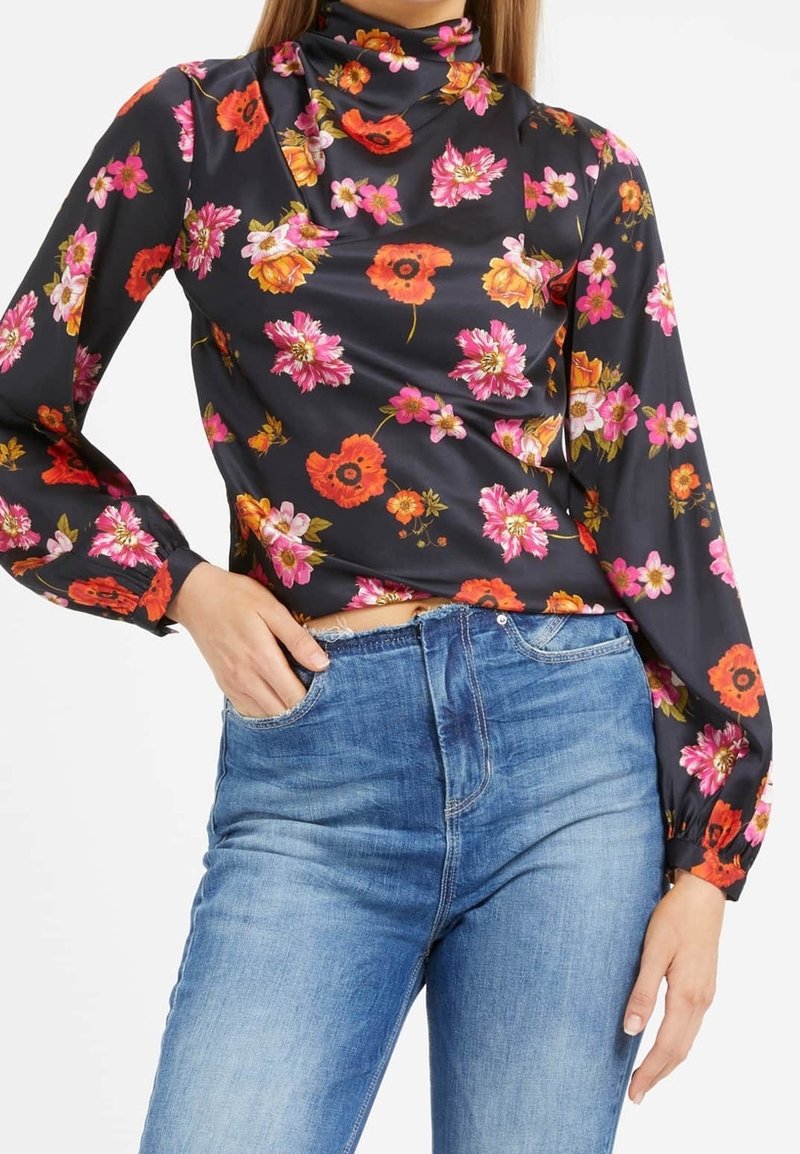 Blouse noire à fleurs avec manches longues, ornée de fleurs multicolores en rose, orange et jaune. Conçue avec un col montant et une texture lisse.