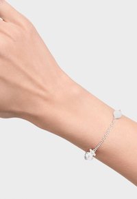 Bracciale d'argento con catena e ciondolo rotondo, caratterizzato da una texture liscia. La catena è delicata e complementa il design minimalista.