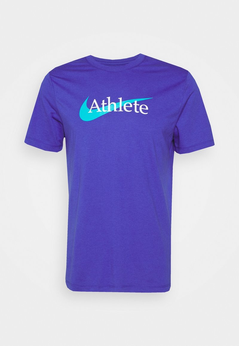 Camiseta de algodón morada con un logo blanco de "Atleta" y un diseño de swoosh azul. Manga corta y escote redondo.