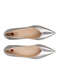 Srebrne baleriny z ostrym noskiem, o metalicznym wykończeniu, gładkiej fakturze i delikatnie wygiętym otworze na górze. Wnętrze jest w kolorze cielistym.