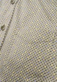 Kurzarmhemd aus grünem Stoff mit Karomuster, das kleine blaue, gelbe und weiße Quadrate zeigt. Mit einer Brusttasche und Stickdetails.