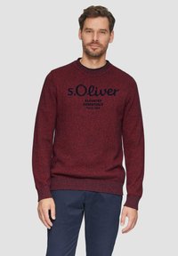 Bordeauxroter Strickpullover mit gerippten Bündchen und Saum. Mit dem Logo "s.Oliver" in Marineblau auf der Brust. Klassisches Rundhalsdesign.