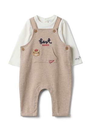 Beigefarbener Baby-Overall mit Holzknöpfen, Fronttasche, Bärenapplikation und weißem Langarmshirt darunter mit Text auf dem Ärmel "play to."