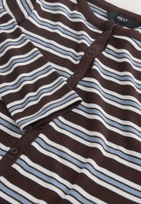 Cardigan marron côtelé avec des rayures horizontales bleues et blanches, col rond et boutons noirs à l'avant.