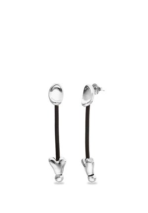 Pendientes de tono plateado con tallos negros alargados, parte superior redondeada y detalles escultóricos en la parte inferior, con cierres de tipo poste.