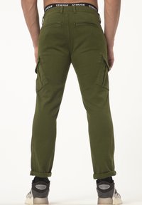 Groene cargobroek met een tapered fit, voorzien van zijzakken en een cuffed zoom. Gemaakt van zachte stof met een gladde textuur.