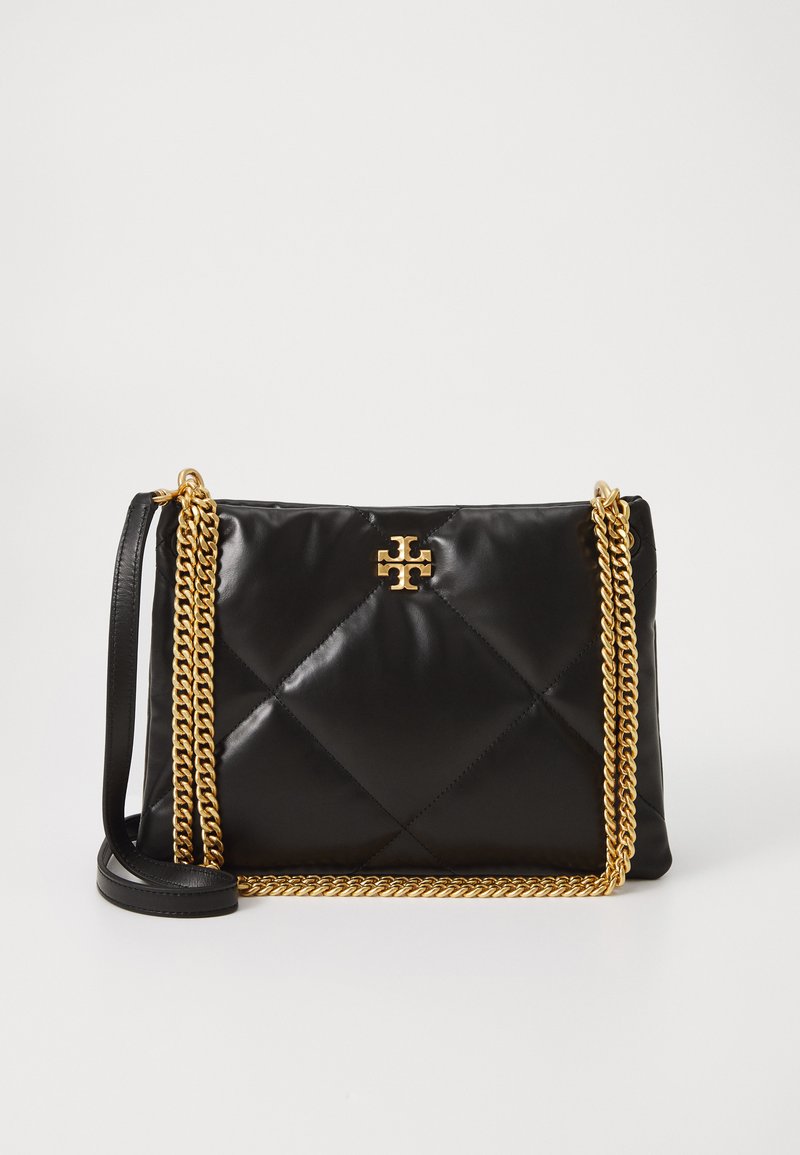 Črna prešita torbica iz sijočega materiala, opremljena z zlatim verižnim ročajem in izrazitim logotipom na sprednji strani.